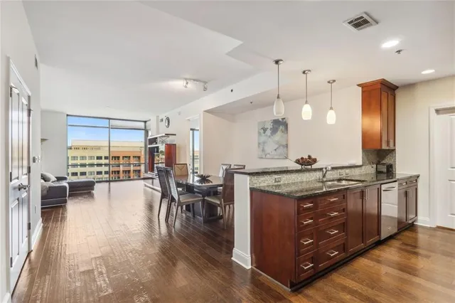 a spacious kitchen with stainless steel appliances granite countertop a lot of counter space and wooden floors