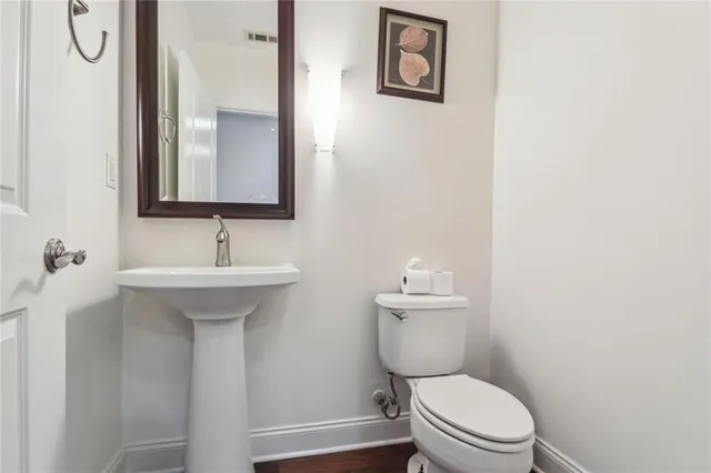 a bathroom with a toilet sink vanity and mirror