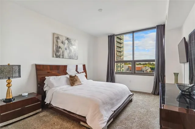 a bedroom with a bed and a dresser next to a window