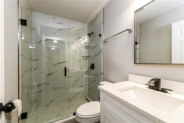 a bathroom with a sink a toilet and shower