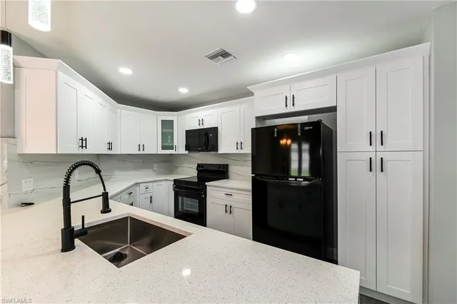 a kitchen with stainless steel appliances kitchen island granite countertop a refrigerator sink and stove