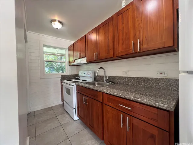 a kitchen with stainless steel appliances granite countertop a sink stove and cabinets