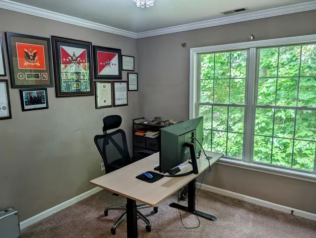 a view of a workspace with furniture and a window