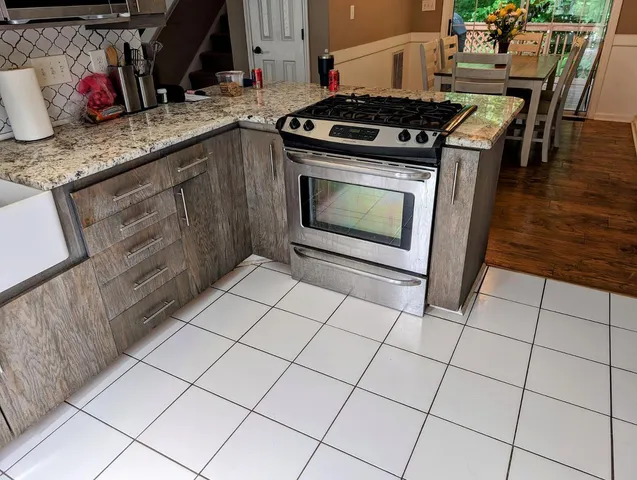 a kitchen with granite countertop a stove a sink and a microwave