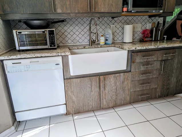 a kitchen with stainless steel appliances granite countertop a sink and a microwave