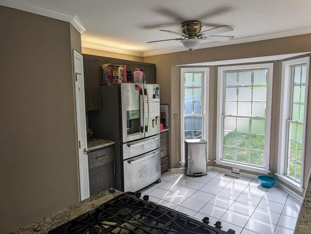 a kitchen with a refrigerator and white cabinets