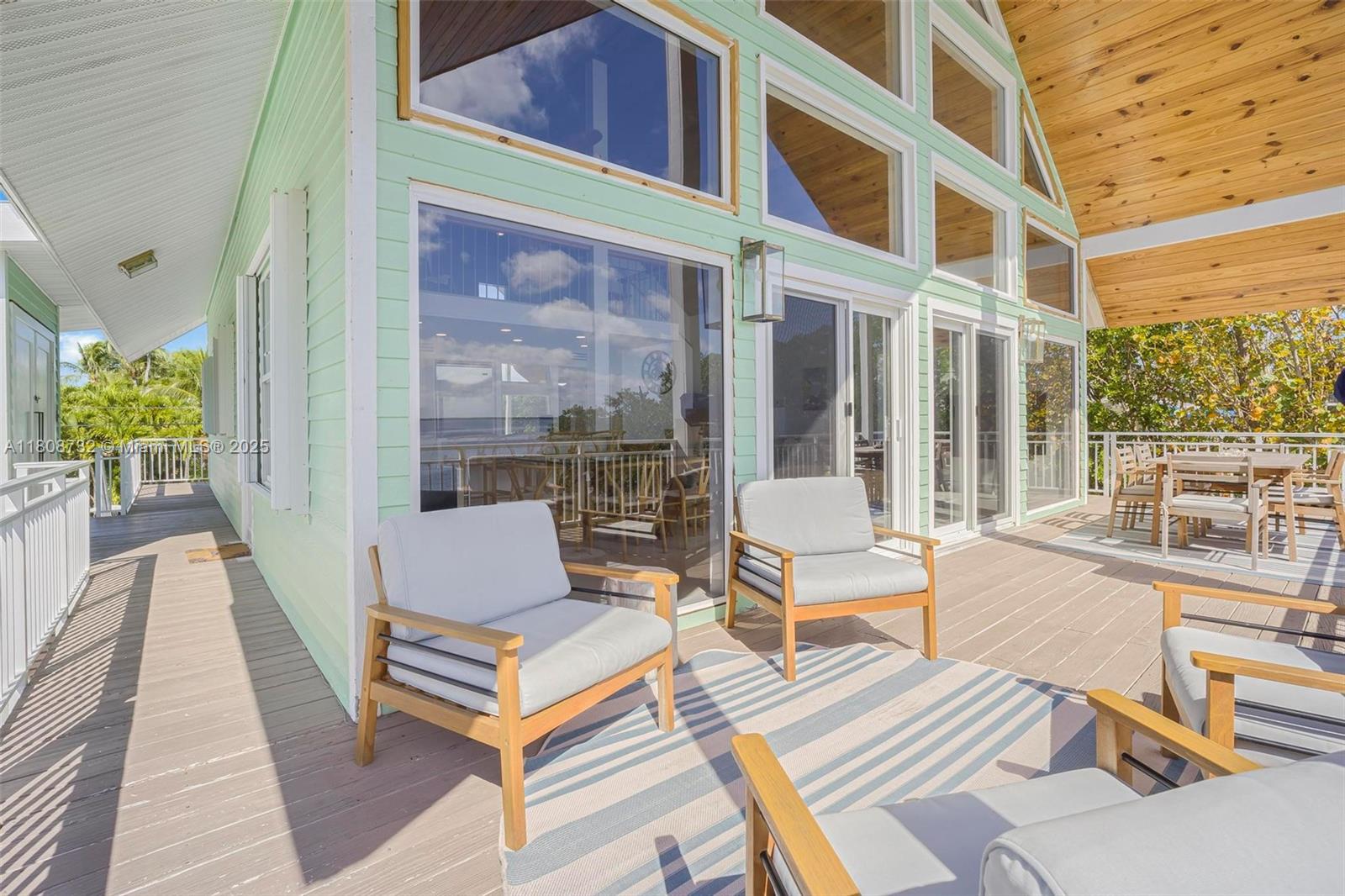 41 Mutiny Place Key Largo, FL 33037 - Photo 14 of 69 a view of a patio with couches table and chairs with wooden floor and fence
