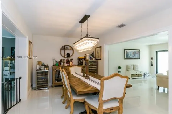 a view of a dining room with furniture a chandelier and wooden floor
