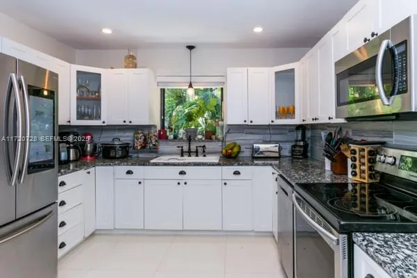 a kitchen with stainless steel appliances a sink stove and cabinets