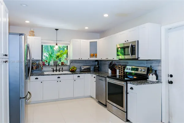 a kitchen with white cabinets and stainless steel appliances