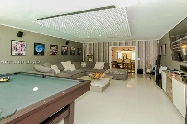 a living room with furniture pool table and a flat screen tv