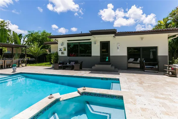 a view of a house with swimming pool and sitting area