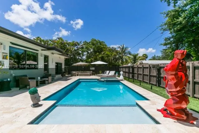 a view of backyard with table and chairs under an umbrella