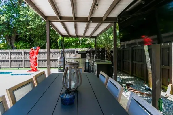 a view of a chairs and table in patio with a barbeque grill