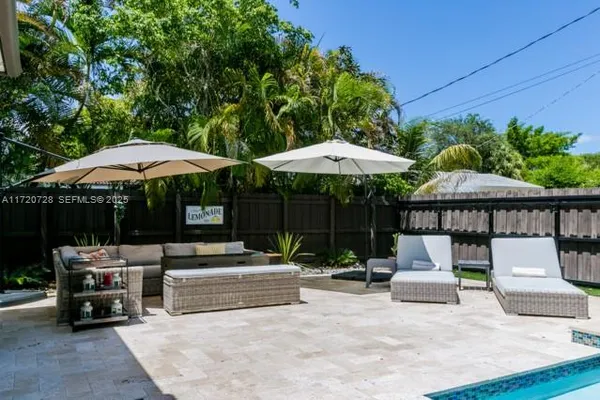 a view of backyard with table and chairs under an umbrella