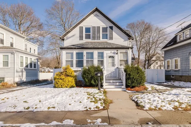 a front view of a house with a yard covered with snow in front of house