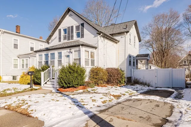 a view of a house with snow on the side of the road