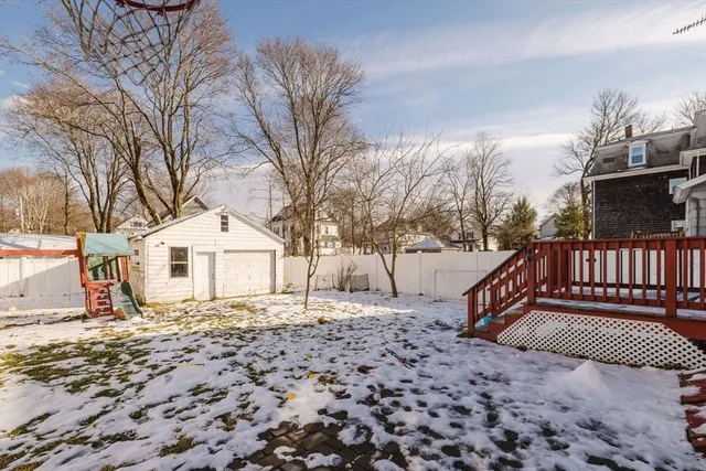 a view of a house with a wooden bench next to a yard