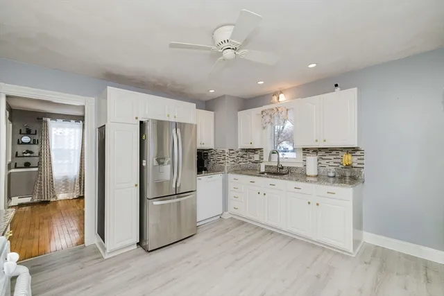 a kitchen with white cabinets and stainless steel appliances