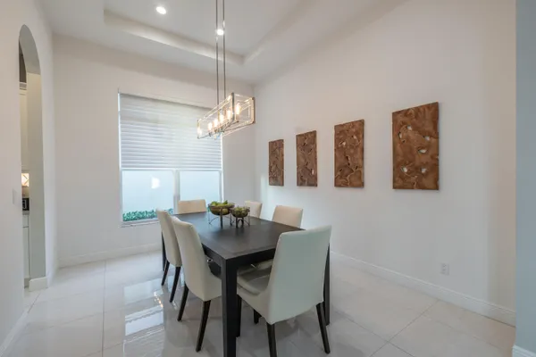 a living room with furniture a chandelier and a dining table
