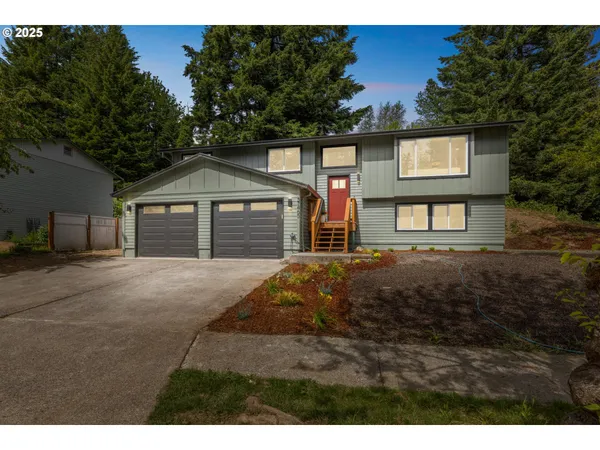 a front view of a house with a yard and garage