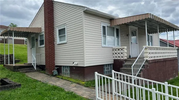 a view of a house with a yard and furniture