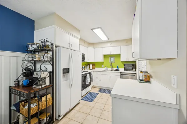 a kitchen with a refrigerator and a stove top oven
