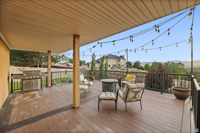 2342 Charros Road Sandy, UT 84092 - Photo 65 of 94 Expansive covered deck featuring wood-finish composite decking, sturdy support pillars, and black metal railings