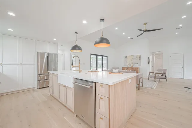 a kitchen with stainless steel appliances granite countertop a sink a stove and a wooden floors