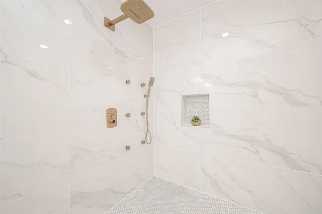 a bathroom with a double vanity sink mirror and shower
