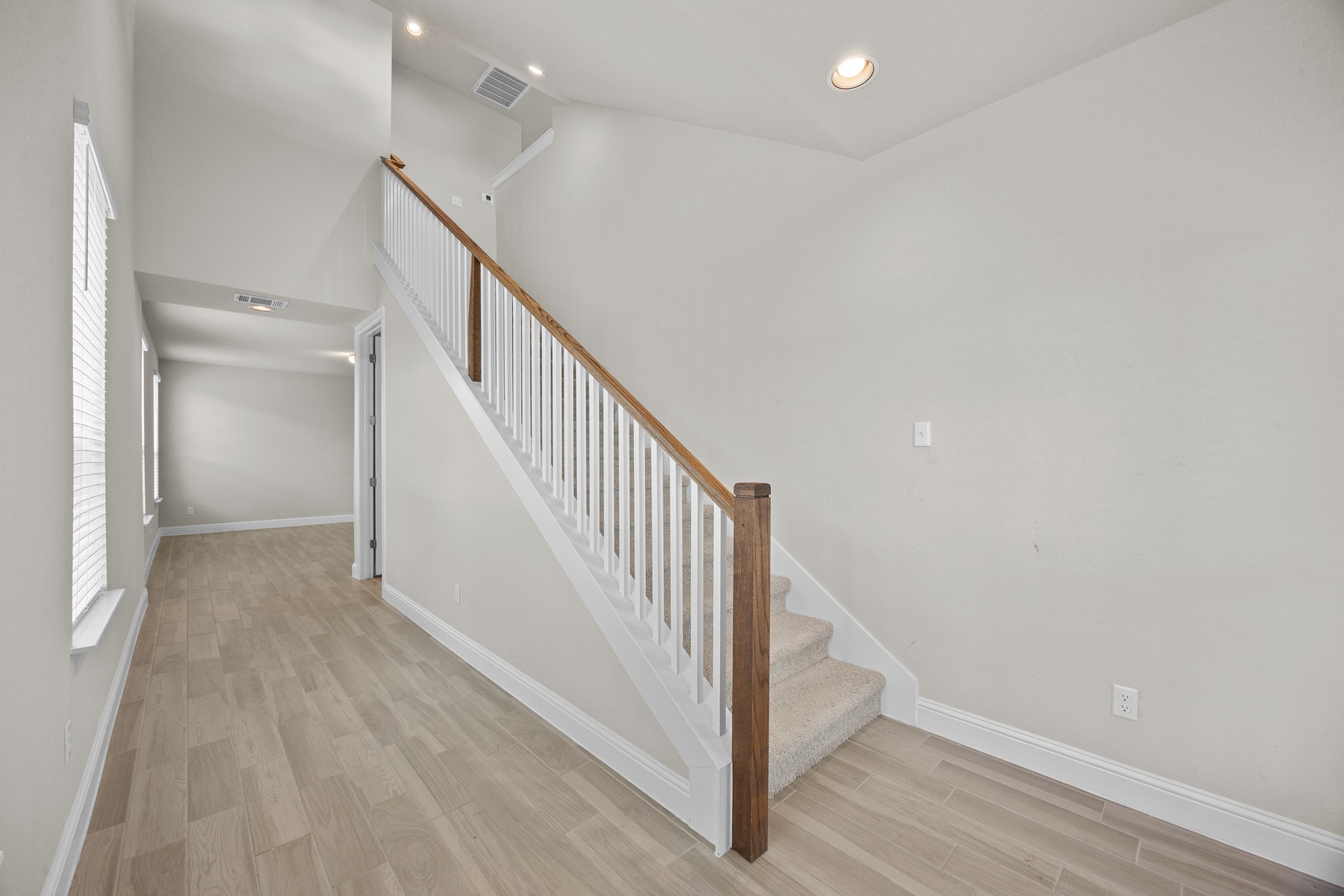 213 Graver Street Georgetown, TX 78626 - Photo 33 of 33 Enter into a bright, open floorplan with durable wood-look tile flooring leading to a carpeted staircase.