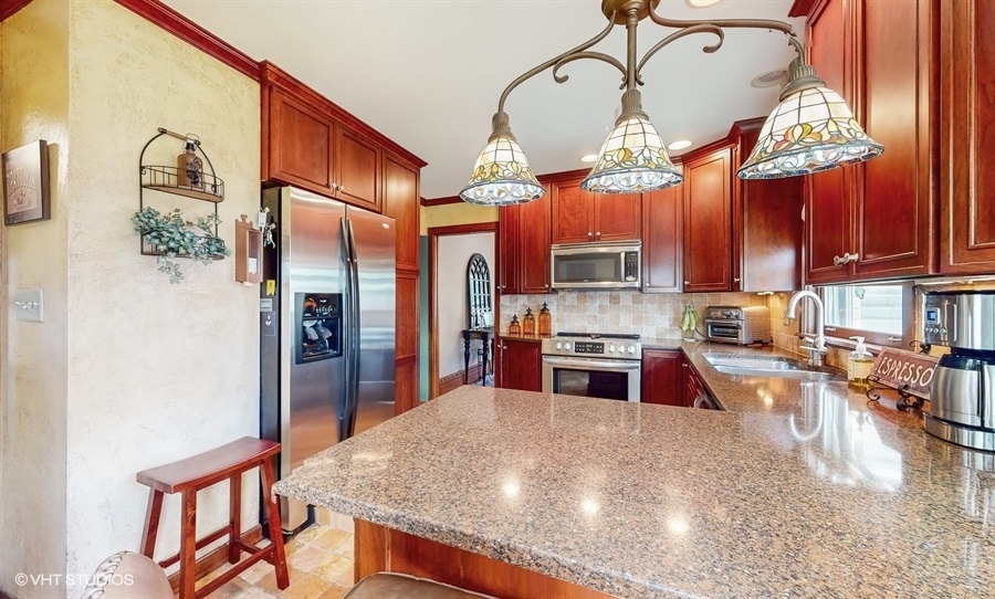 633 Oakland Avenue Elgin, IL 60120 - Photo 12 of 35 a kitchen with stainless steel appliances granite countertop a sink a stove and a wooden floors