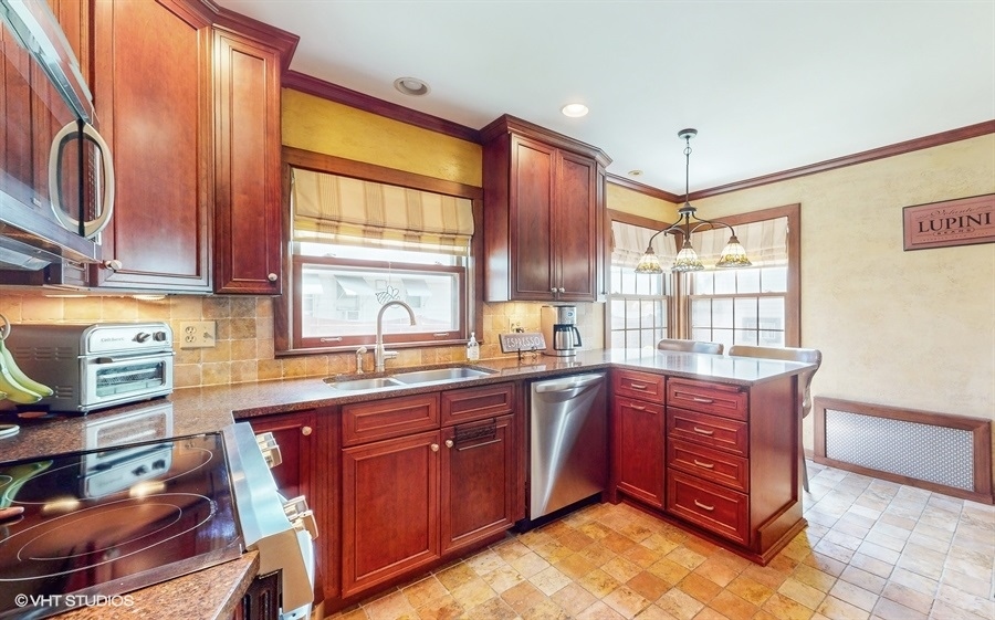633 Oakland Avenue Elgin, IL 60120 - Photo 10 of 35 a kitchen with stainless steel appliances granite countertop wooden cabinets a sink and a window