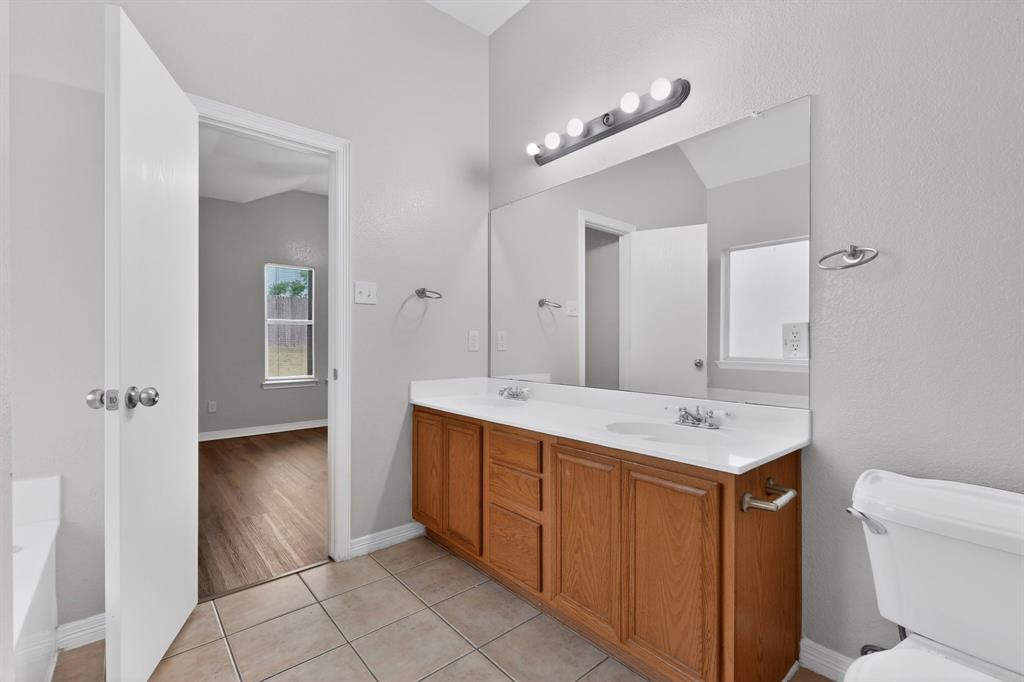 3401 Newgate Street Midlothian, TX 76065 - Photo 24 of 34 Bathroom featuring a dual vanity with a light wood finish, a white countertop, and a large wall-mounted mirror