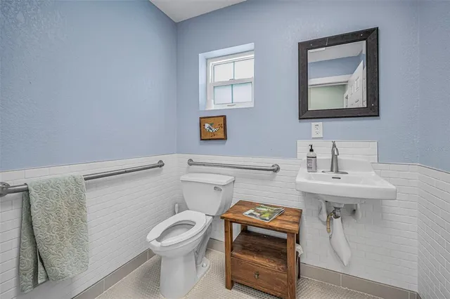 a bathroom with a toilet a sink and mirror