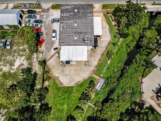 an aerial view of residential house with outdoor space and trees all around