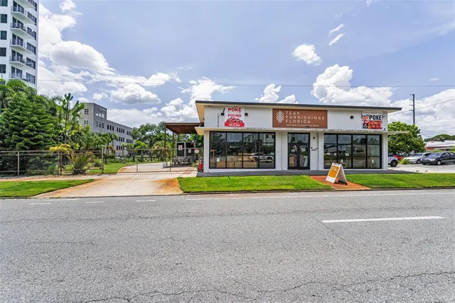 a view of multi story building with a big yard and large trees