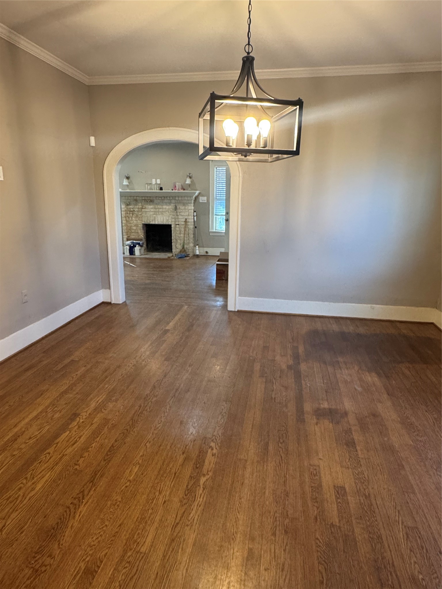 2307 Arbor Street, Unit 1 Houston, TX 77004 - Photo 9 of 11 an empty room with wooden floor fireplace and chandelier