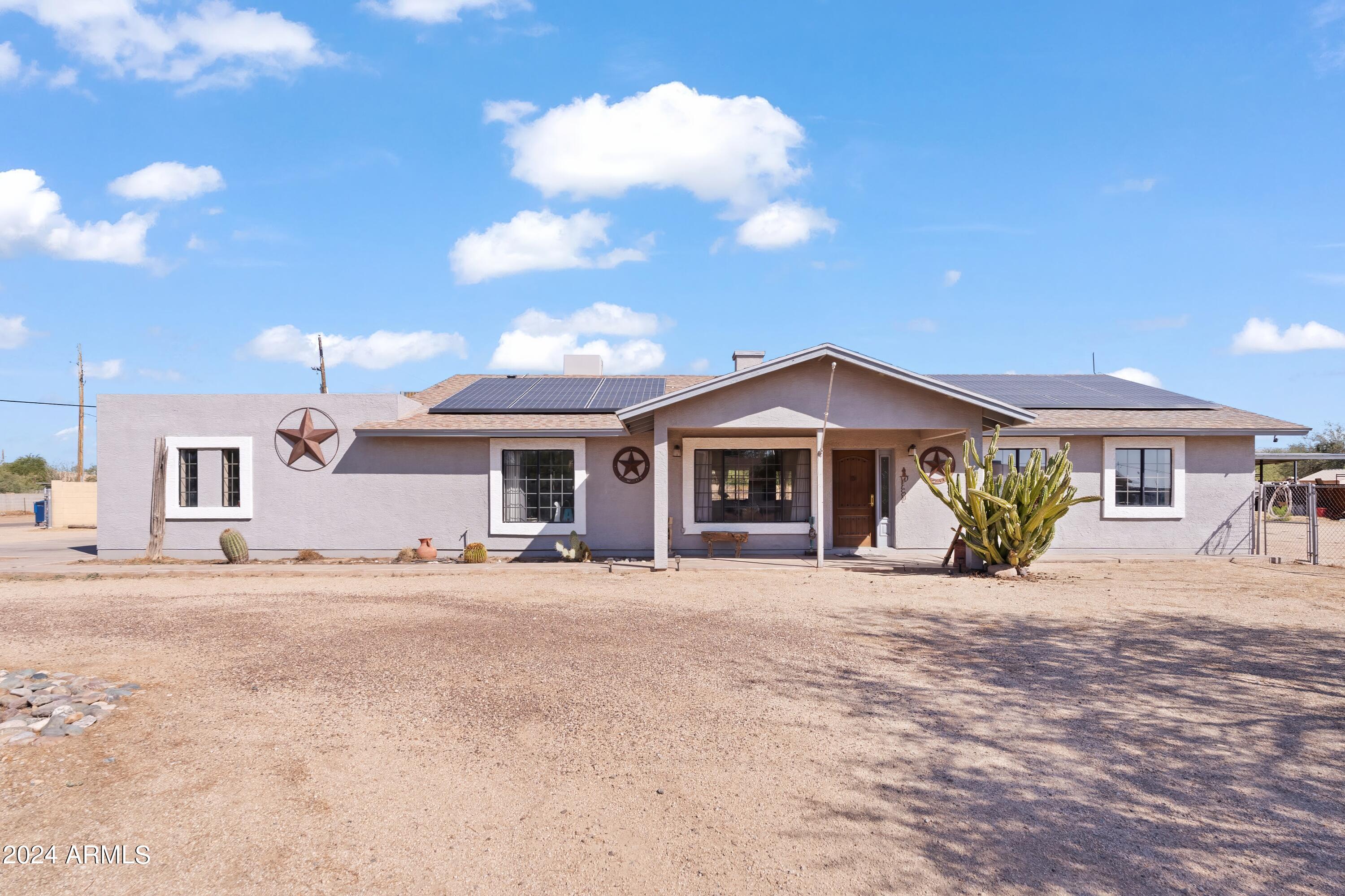 a view of a house with a yard and large tree