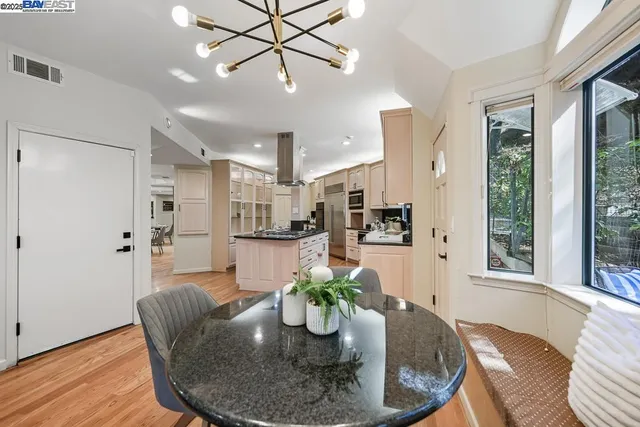 a view of a dining room with furniture a chandelier and wooden floor
