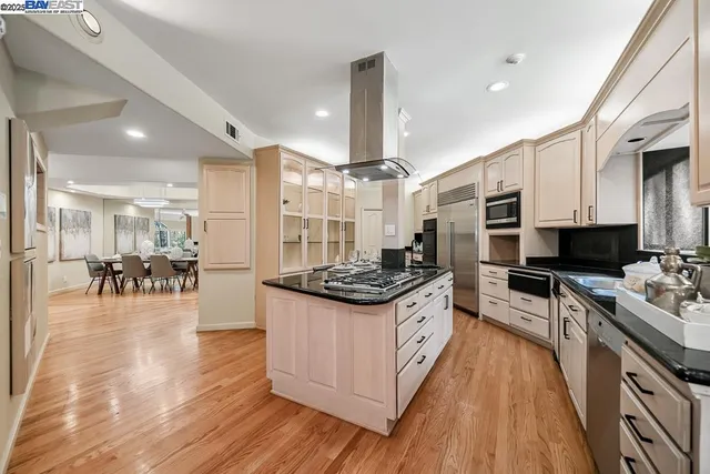 a kitchen with stainless steel appliances granite countertop a stove and a wooden floors