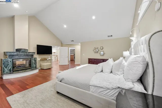 a large white kitchen with a window and refrigerator