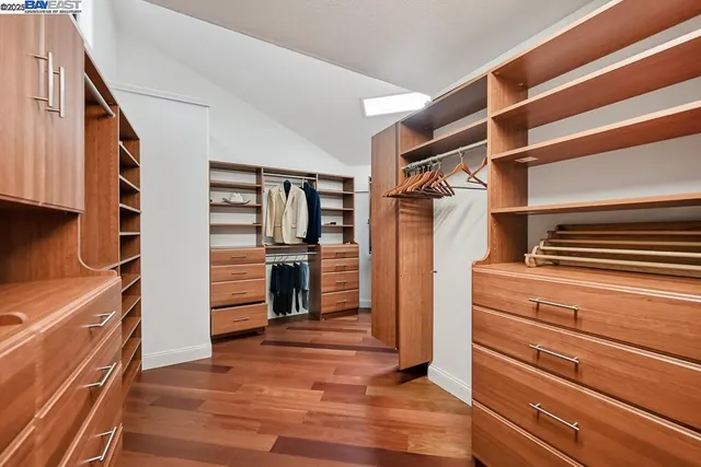 a bathroom with a sink a large mirror and a clock on the wall