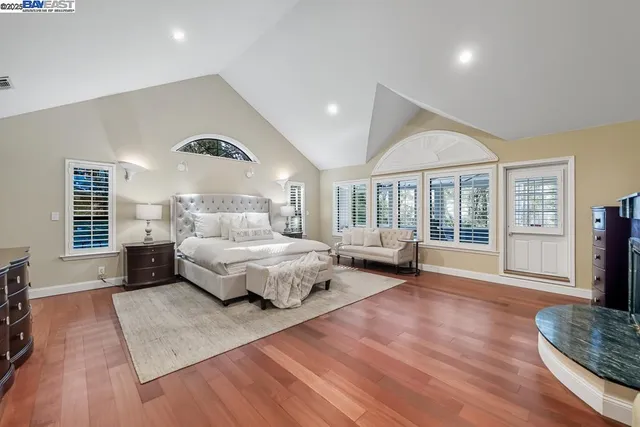 a bedroom with a bed and a flat tv screen on dresser