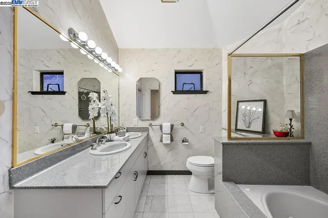 a spacious bedroom with a large bed and a chandelier