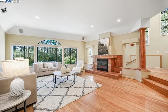 a living room with furniture a fireplace and a large window