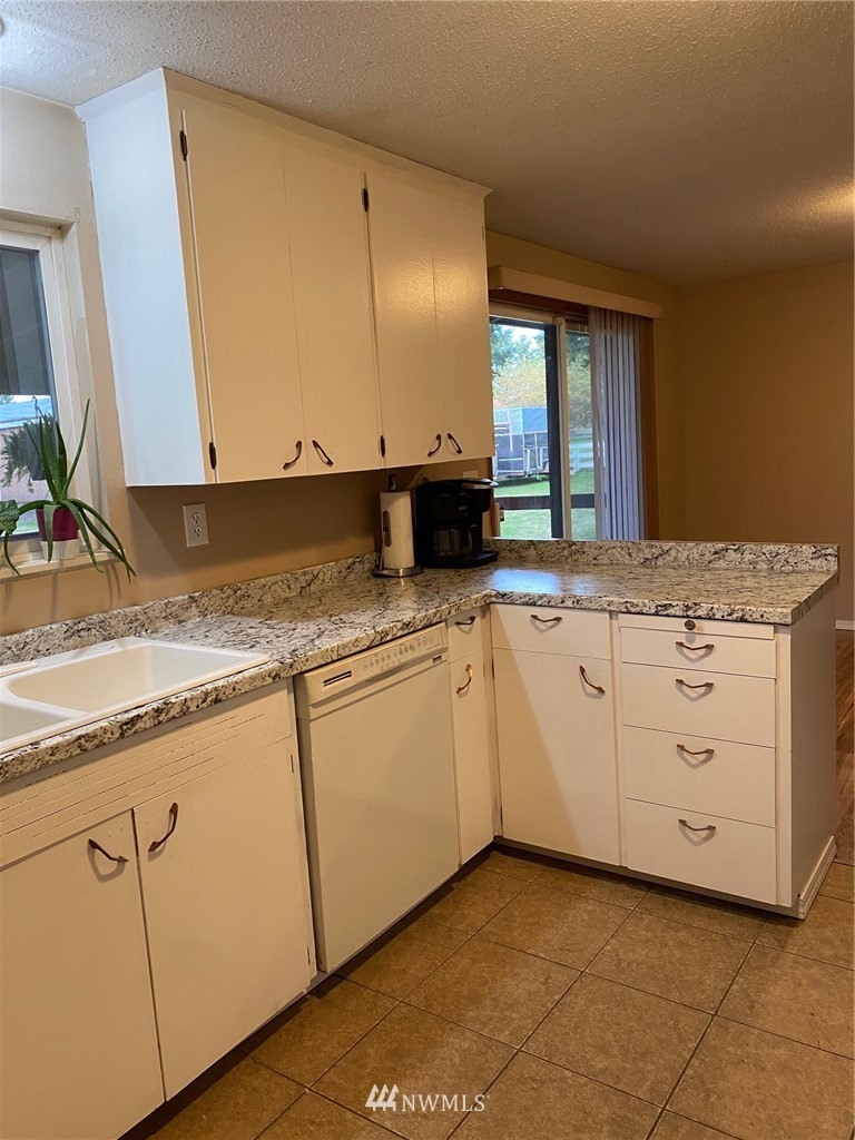 19147 Old Highway 99 Southwest Rochester, WA 98579 - Photo 10 of 27 a kitchen with granite countertop white cabinets and white appliances