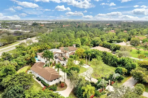 an aerial view of residential houses with outdoor space and trees