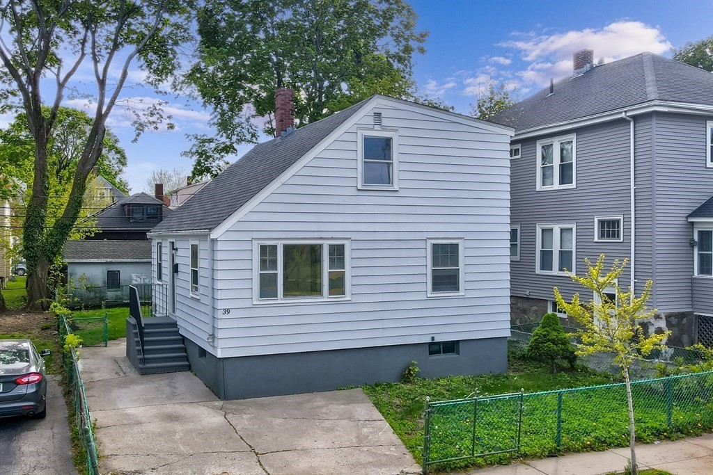 a view of a house with a yard and potted plants