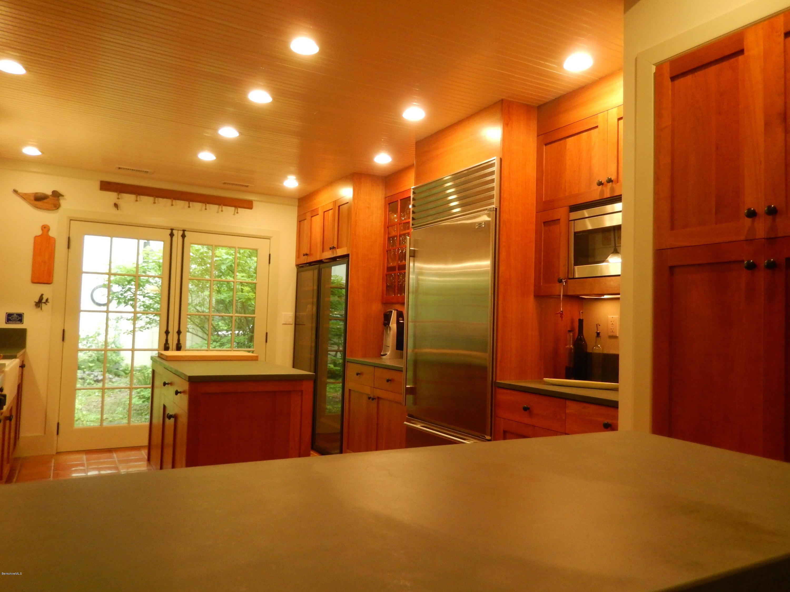 53 Reservoir Road Richmond, MA 01254 - Photo 21 of 37 a kitchen with stainless steel appliances kitchen island granite countertop a refrigerator and wooden cabinets